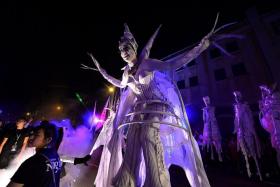 A WALK IN THE DARK: (Above) In Let&#039;s Celebrate, performers on stilts wove their way among the crowd. 