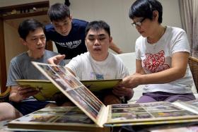 LOOKING BACK: (Above) Foo Hou Jing and his family looking through old photos. 