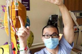 HAPPY: Mr Edwin Chen poses with his IV drip in his ward.