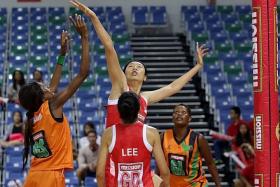 DEFENCE: Singapore&#039;s Chen Lili (below) attempts to block a shot from a Zambia player in their match in the Mission Foods Nations Cup.