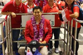 SUPPORT: Tan and fellow para-athlete Suhairi Suhani (standing, with garland) and their friends at the airport yesterday.