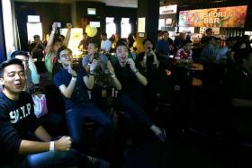 WELL DONE: Football fans cheering a Manchester United goal at the Tiger-TNP Sports Bar at Shanghai Dolly in Clarke Quay yesterday.  
