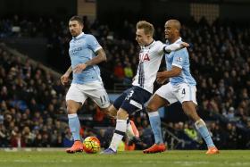 Tottenham midfielder Christian Eriksen shields the ball from Man City defender Vincent Kompany during their match at the Etihad Stadium in February 2016.