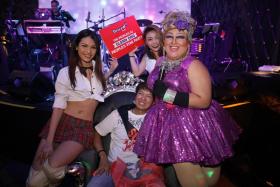 One FM 91.3 DJ Glenn Ong (seated) looking dazed after getting a lap dance from two dancers and Nella “The BarbieBoy”.