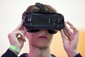 A boy uses a Samsung Gear VR virtual reality headset by Oculus at the Deutsche Telekom booth during preparations at the CeBit computer fair in Hanover.