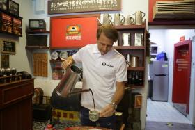 Former Spain midfielder Gaizka Mendieta trying his hand at making a cup of traditional Singapore coffee.