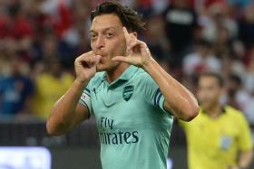 Mesut Oezil celebrates after scoring the opener in their 5-1 win over Paris Saint-Germain.