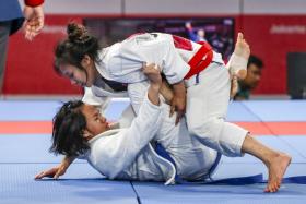 Singapore's Constance Lien (on top) defeating Thailand's Onanong Sangsirichok in the Round of 16 of the women's jujitsu 62kg category.