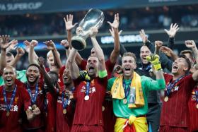 Liverpool captain Jordan Henderson lifting the European Super Cup.