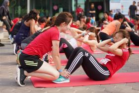 Participants at the sit-up station of the GE Women's Individual Physical Proficiency Test (IPPT).