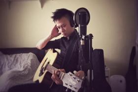 Mr Cliff Lee, 32, preparing to busk online on Facebook in his room.