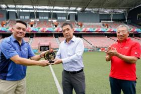 Secretary-General of the Singapore National Olympic Council Chris Chan (centre) presenting the 2019 IOC Trophy to Our Tampines Hub senior director Suhaimi Rafdi, with International Olympic Committee vice-president Mr Ng Ser Miang looking on.