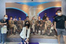 Mr Michael Lin (right) and his friends taking a picture with a life-size replica of BTS at Suntec City