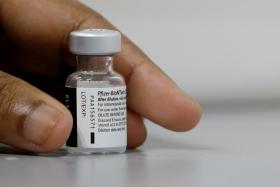 A medical worker prepares to dilute a vial of Pfizer-BioNTech vaccine at a coronavirus disease (COVID-19) vaccination center in Singapore March 8, 2021.