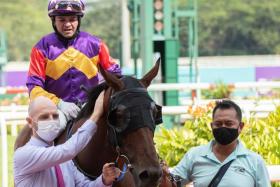 Leading trainer Tim Fitzsimmons giving his favourite horse Lucky Jinsha (jockey Manoel Nunes astride) a pat after the gelding’s last victory at Kranji on March 13. It was the Lucky Unicorn Stable-owned four-year-old’s fifth win in his last six starts. 