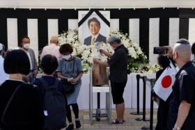 Mourners offer flowers at the altar outside Nippon Budokan Hall which will host a state funeral for former Prime Minister Shinzo Abe in Tokyo, Japan, Sept 27, 2022.