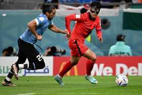 South Korea captain Son Heung-min (in red) getting past Uruguay&#039;s Martin Caceres during their opening World Cup Group H match in Al Rayyan, west of Doha on Thursday (Nov 24). 