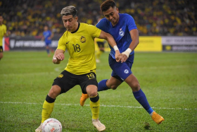 Malaysia&#039;s Brendan Gan (left) and Singapore&#039;s Amy Recha tussling for the ball during the hosts&#039; 4-1 win in Kuala Lumpur. 
