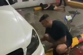 All in a day's work: Man casually washes car while police arrest suspects behind him