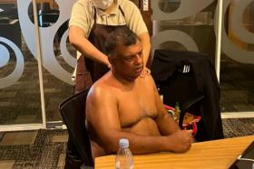 A shirtless Tony Fernandes, AirAsia CEO, getting a massage during a conference call. 
