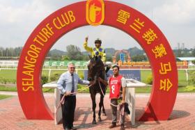Laxon being led to his first win at the Selangor Turf Club on May 18. He was ridden by apprentice jockey Fikri Ismail and has trainer Shane Ellis by his side at the winner&#039;s circle. Ellis was the late Laurie Laxon’s B trainer at Kranji.
