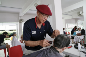 Mr Mark Yuen giving free haircut in Tiong Bahru earlier this month.