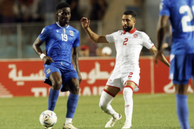 Tunisia player Ali Abdi (in white) and Equatorial Guinea player Luis Asue.