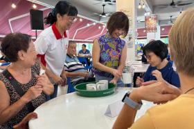 Dr Amy Khor serving seniors their drinks during the launch.