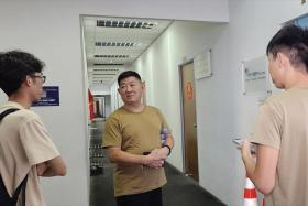 Mr Huang (centre) were among the 50 drivers who showed up to the centre to collect their VEPs.