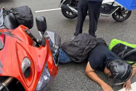 Mr Djohan Abdul Rahman lying on the road after he was caught between a car and a bus in a traffic accident.