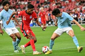 Singapore&#039;s Naqiuddin Eunos (in red) against Cambodia players during the AFF Championship Group A match at the National Stadium on Dec 11.