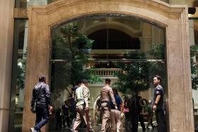 Policemen seen in the Grand Hyatt Erawan hotel, where at least six people were reported dead, in Bangkok on July 16.