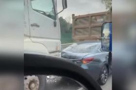 A video posted on Facebook showed a blue car with a damaged rear bumper between two trucks.