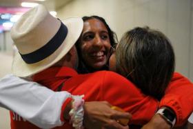 Shanti Pereira (centre) hugging her parents Clarence (left) and Jeet after winning the women&#039;s 200m crown at the Asian Games.