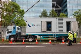 SP Group staff demonstrating how they set up a mobile power generator.