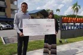 Hassan Sunny presenting a $10,000 cheque to Muhammadiyah Welfare Home's head Rahmatunnisa Abdul Majeed.
