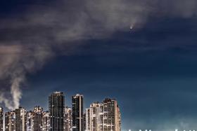 Streams of smoke could be seen coming up from the buildings below, which looked to be 'welcoming the comet', said recreational photographer James Gan.