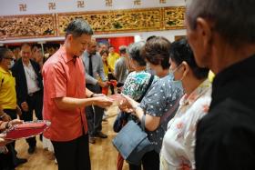 Education Minister Chan Chun Sing, who was at the Singapore Buddhist Lodge to officially open its Donor Plaque Pavilion, distributing hongbao to beneficiaries on Jan 11.