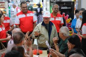 Dr Tan Cheng Bock (centre) and other Progress Singapore Party members and volunteers greeting people during a walkabout in Keat Hong Shopping Centre on Jan 12.