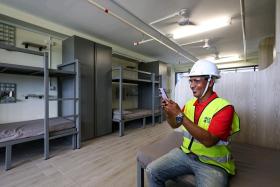 Mr Sumun Biswas, 44, hydraulic operator, taking a photo of the sample dormitory unit at MOM&#039;s purpose-built dormitory at Tukang Innovation Lane on Nov 17.