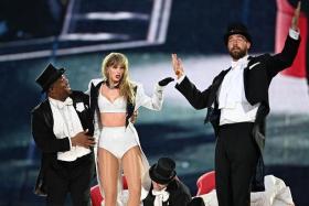 Taylor Swift is joined onstage by Travis Kelce (right) during The Eras Tour at Wembley Stadium in London, England, on June 23.