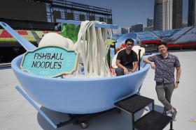 Large-props designer Deric Shen (left) and multimedia director Davier Yoon with the giant fishball noodles food prop at the Padang, on July 26.