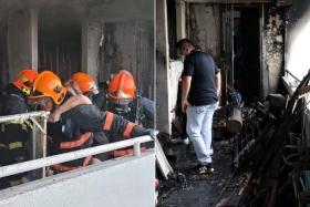 SCDF personnel during the fire that broke out in a Bedok North Avenue 2 flat on May 13 last year and the aftermath.