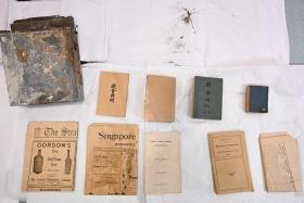 The steel capsule (top left) alongside artefacts that were found in it, including a copy of The Straits Times dated Jan 8, 1924.