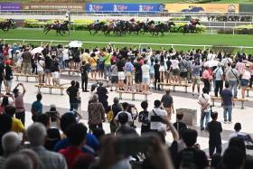 Spectators lining the fence along the periphery of the track to catch the action of the Abdul Mawi Cup at Singapore Turf Club on Oct 5.